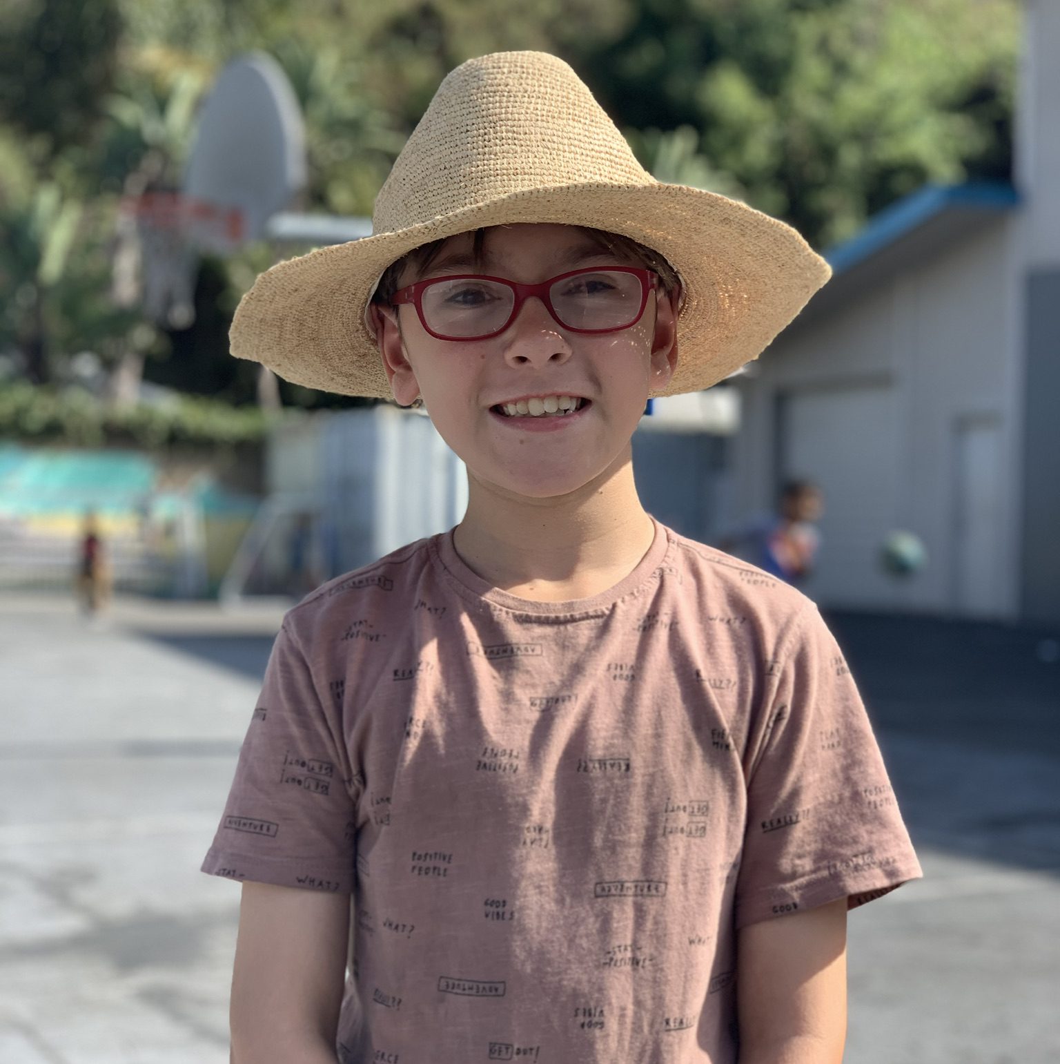 Boy with straw hat on playground at Canyon Enrichment Center